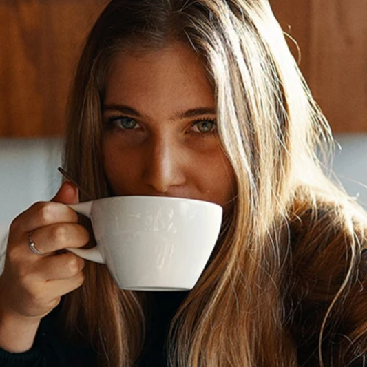 Coffee is good for you: Woman drinking from white coffee cup/mug